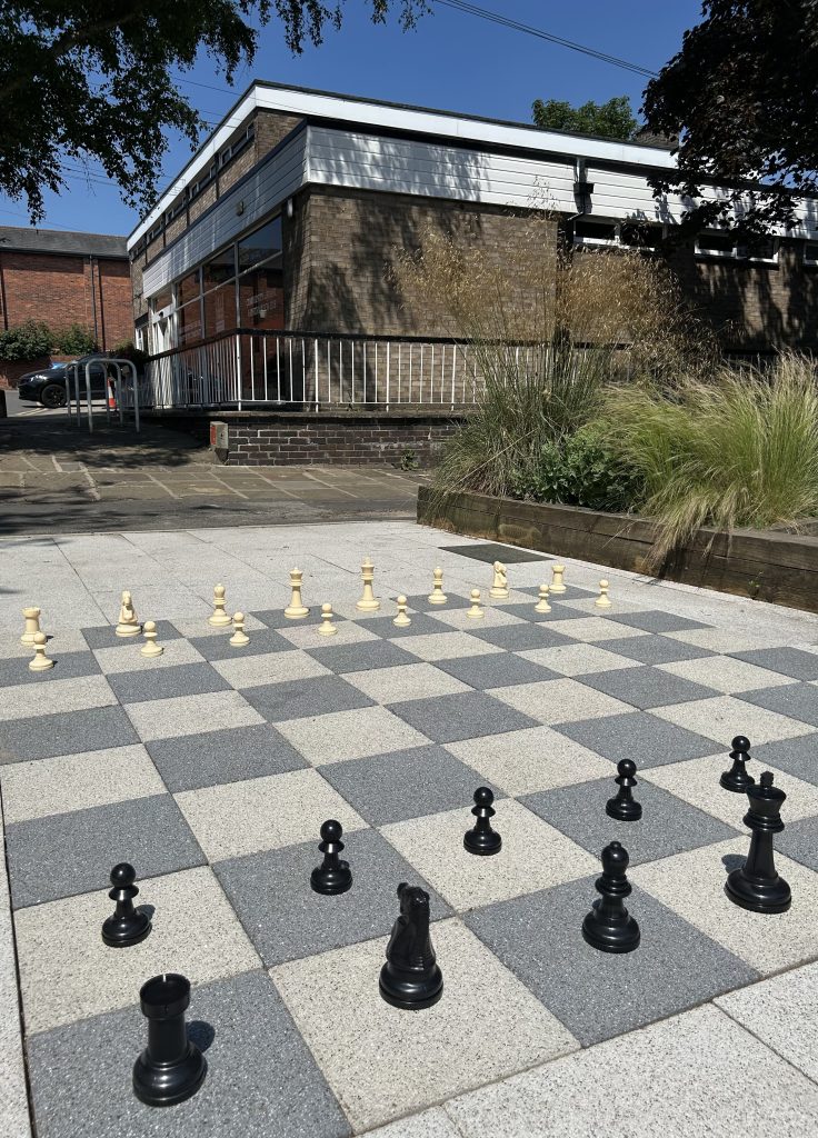 Chess pieces on the chess style paving in the library pocket park